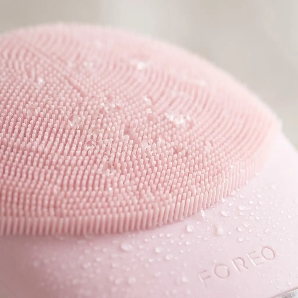 Macro shot of soft FOREO LUNA 3 silicone bristles with water droplets.