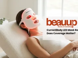 Editorial photo of relaxed woman wearing glowing red light currentbody led mask in luxury home setting.