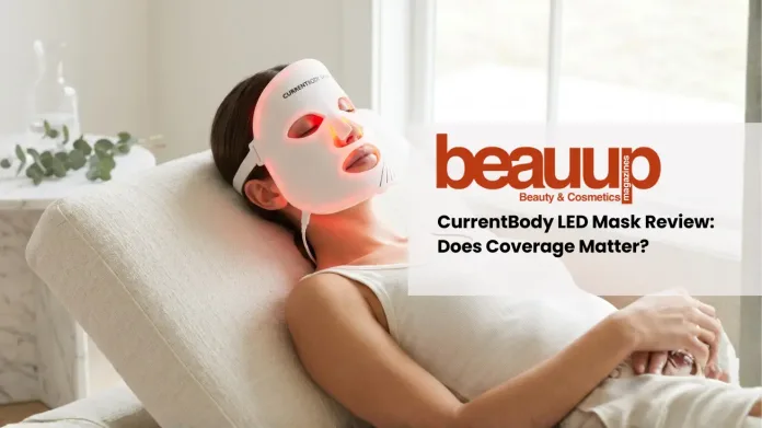 Editorial photo of relaxed woman wearing glowing red light currentbody led mask in luxury home setting.
