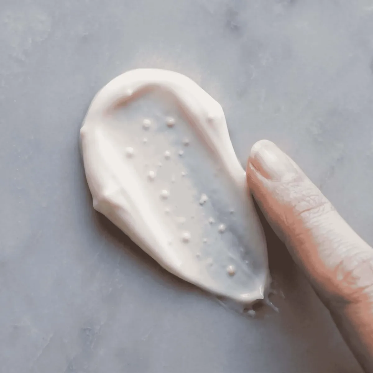 Rich ceramide moisturizer texture swatch on marble, hydration, barrier repair, luxury skincare.